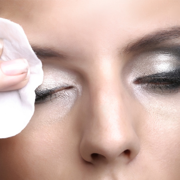 Close-up of a person gently removing silver eye makeup with a cotton pad using Botanical Eye Makeup Remover | Privai for effective and gentle skincare.