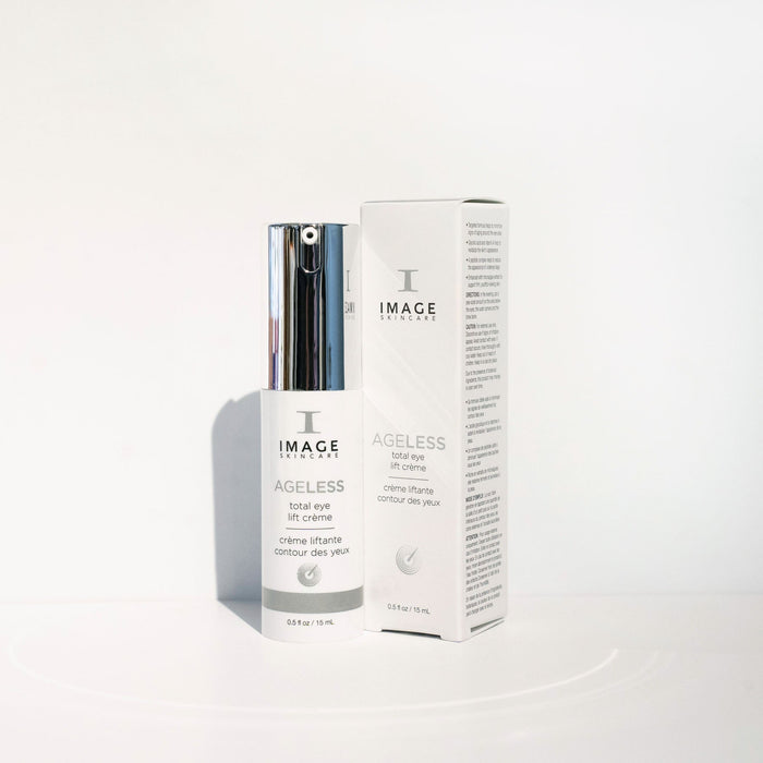 Bottle and box of AGELESS total eye lift crème | IMAGE Skincare with sleek white and silver packaging on a clean white background, highlighting skincare and wellness.