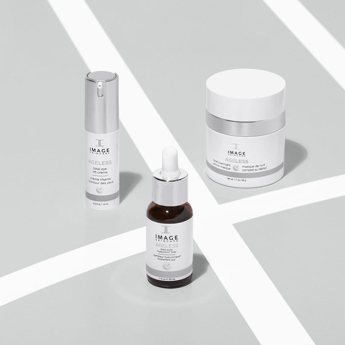 Three IMAGE Skincare AGLESS total eye lift crème | IMAGE Skincare products displayed on a light surface, featuring a pump bottle, dropper bottle, and jar, representing skincare and body care items.