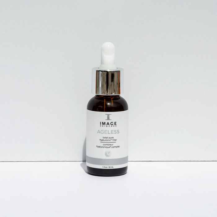 Small amber dropper bottle labeled AGELESS total pure hyaluronic 6 filler | IMAGE Skincare on a plain white background, used for skincare and wellness care.
