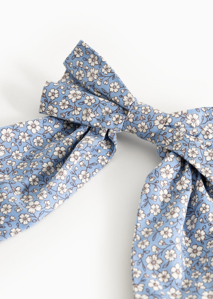 Blooming ribbon in blue with white floral pattern and knot.
