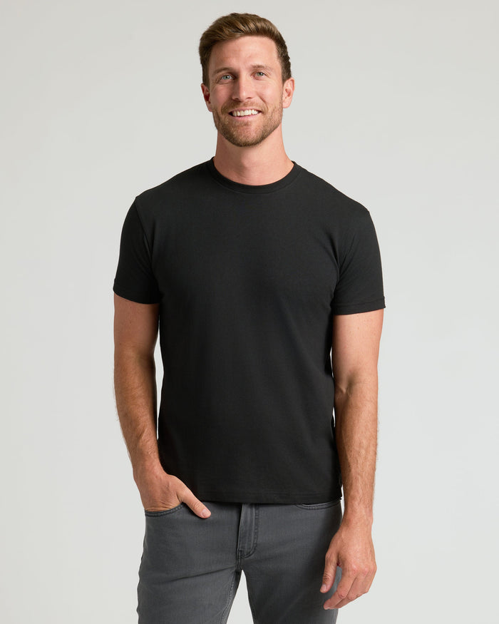 Man wearing a black t-shirt against a gray background