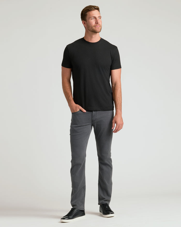 Woodland Shades Crew Neck: Man in black tee, gray jeans, sneakers.