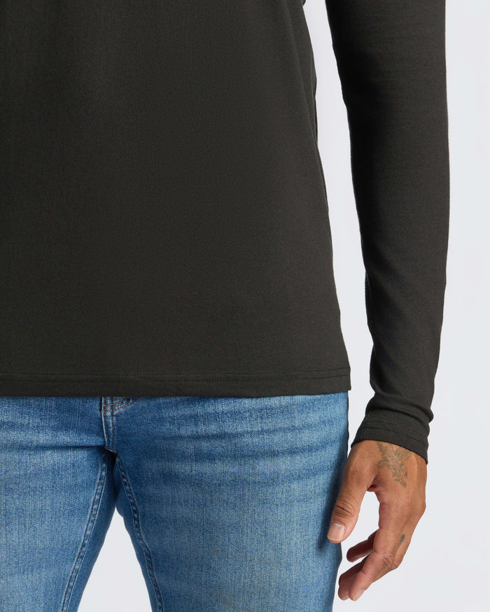 Black Long Sleeve Henley worn tucked into blue jeans.