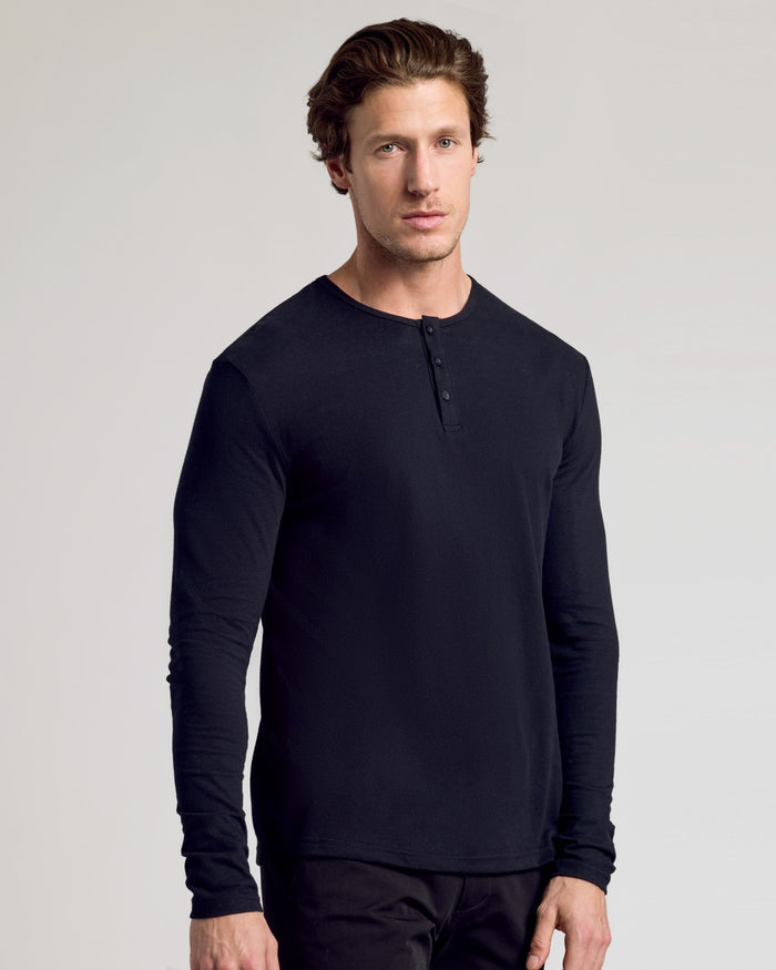 Young man wearing All Black Classic Henley 6-Pack, relaxed pose.