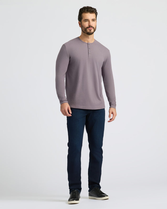 Man wearing Ashberry Classic Long Sleeve Henley, relaxed pose, casual attire.