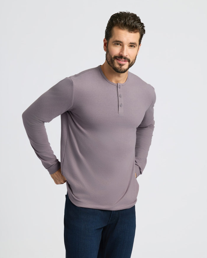 Man wearing Ashberry Classic Long Sleeve Henley with jeans, smiling.