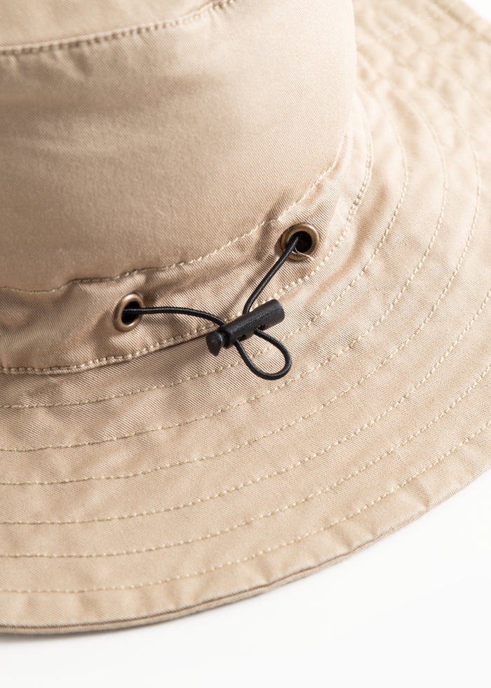 Bright brown cap with adjustable strap and metal snap closure on the side.