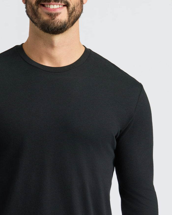 Man wearing Classic Long Sleeve Crew Neck, smiling slightly.