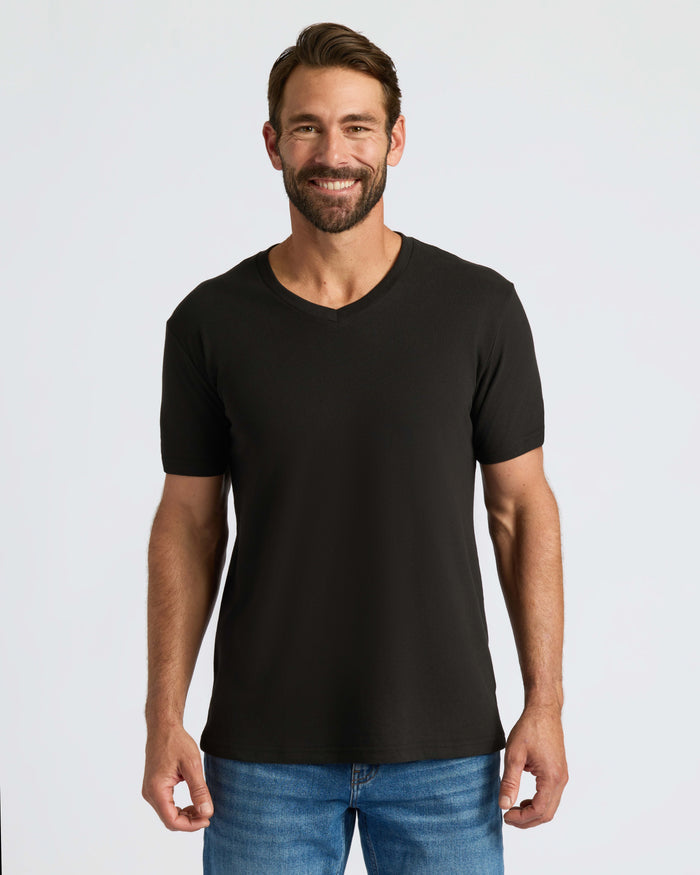 Man wearing Classic V-Neck T-shirt, smiling, arms relaxed by sides.