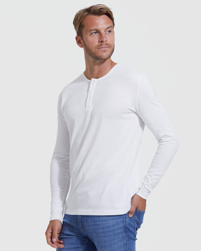Man wearing a white long-sleeve shirt and blue jeans on a white background
