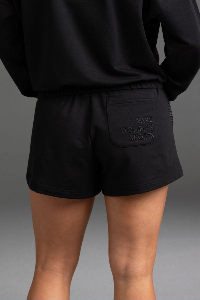 Black shorts with 'Save Women's Sports' pocket on a gray background || Black
