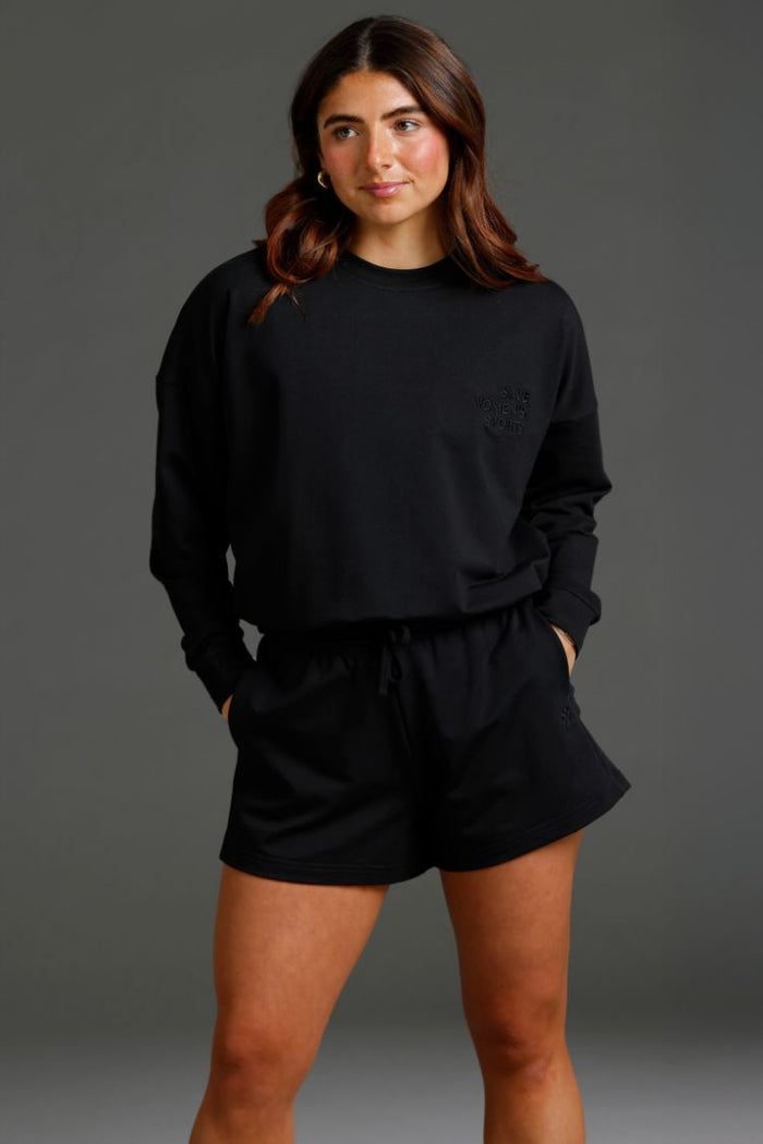 Woman wearing a black outfit against a gray background || Black
