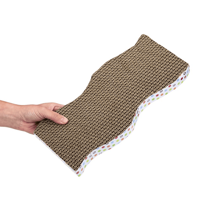 Hand holding wave shaped corrugated cardboard scratcher with spotty details around the outside on a white background.