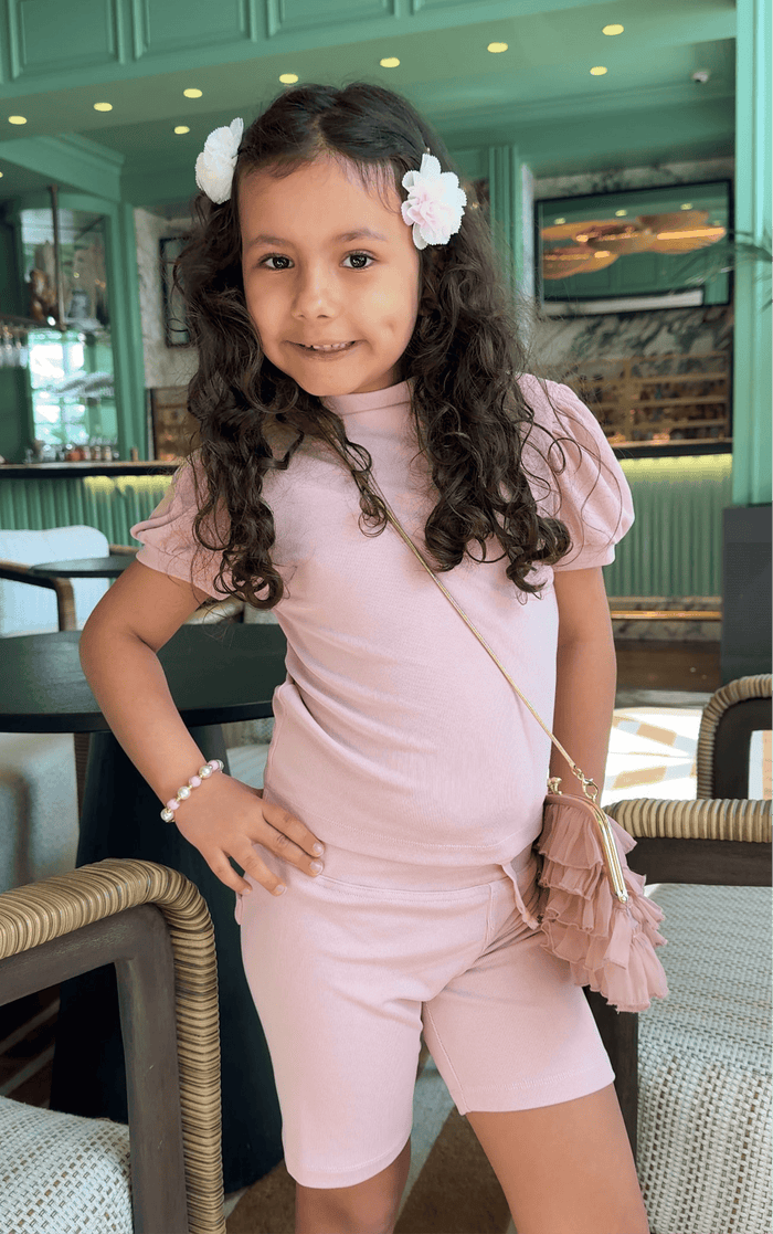 Child wearing Cherry Blossom white and pink hair clips paired with a pastel outfit, featuring soft floral hair accessories for girls