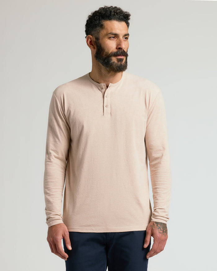Man wearing a beige long-sleeve shirt against a plain background