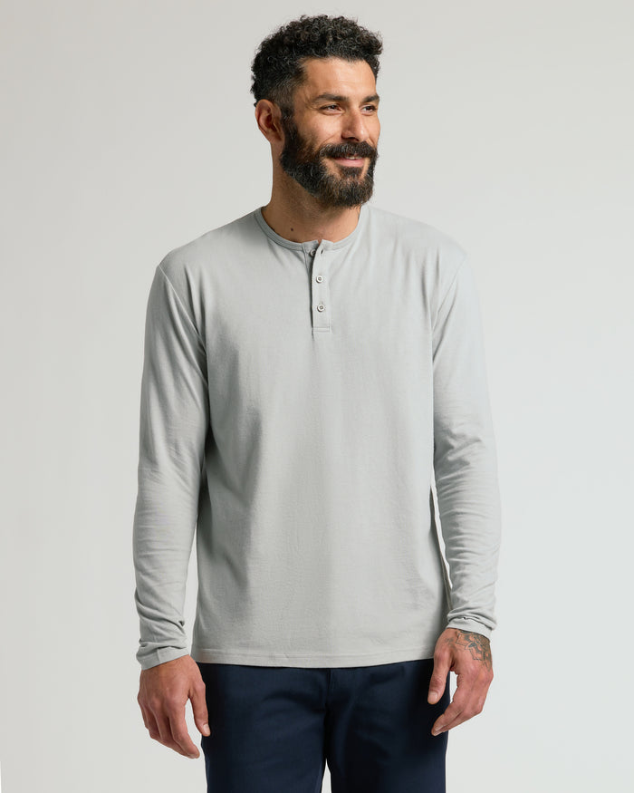 Man wearing a steel long-sleeve shirt against a plain background