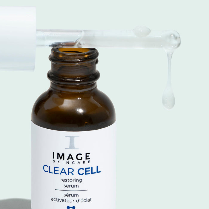 CLEAR CELL Restoring Serum | IMAGE Skincare in an amber glass dropper bottle with a dropper releasing clear serum, highlighting skincare and wellness care.