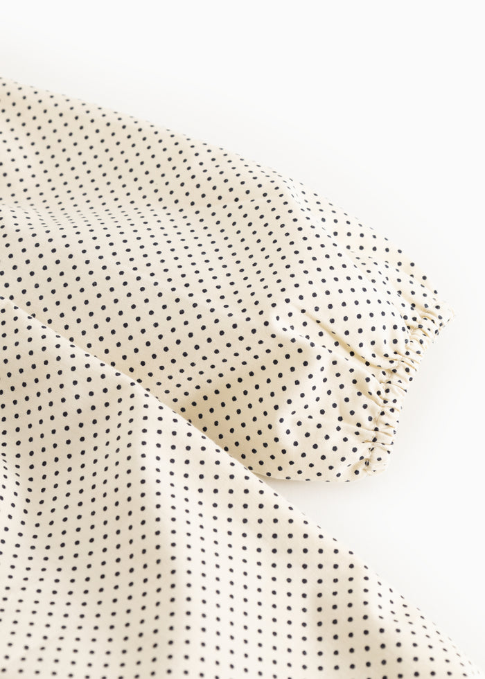 Rimmed edge on a dotted baby dress with small dark dots