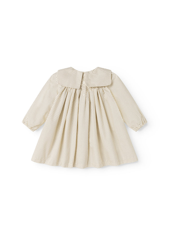 Patterned baby dress with a ruffled collar and a button at the back.