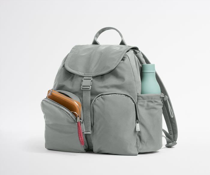 Gray backpack with a water bottle and phone case on a white background