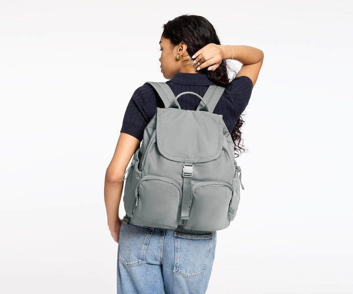 Person wearing a gray backpack on a white background
//
Model is 5'8"