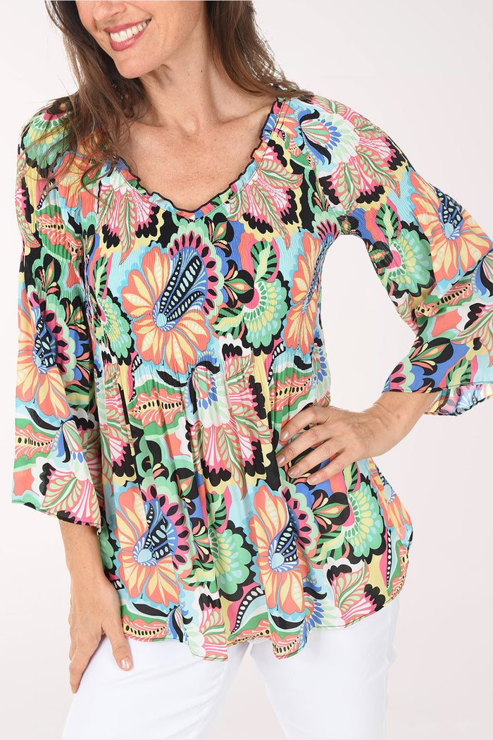 Woman wearing a colorful floral blouse on a white background