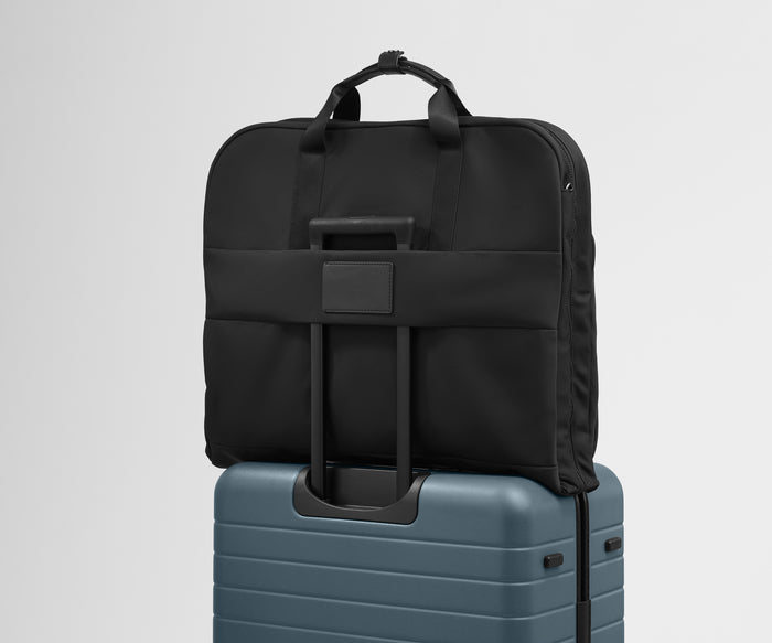 The trolley sleeve on the back of the Garment Bag in Jet Black slides over the trolley handle of an Away Medium suitcase in Coast Blue to make travel seamless
//
The Garment Bag is designed with a trolley sleeve that slides onto your suitcase to keep it in place when you're on the move. Paired with The Medium.