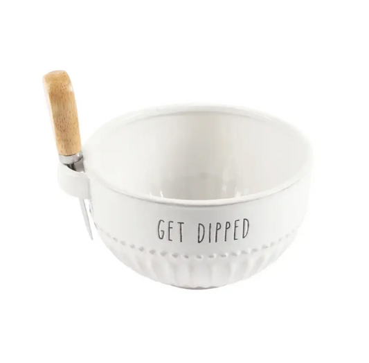 White porcelain dip bowl with wooden handled spreading utensil attached to the side.
