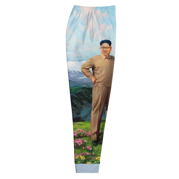 Glorious Dear Leader Joggers - The jarring juxtaposition of the smiling authoritarian figure in #8B7E66 khaki against the hyper-idealized, soft focus #A8D0E6 powder blue sky of a propaganda-style utopia