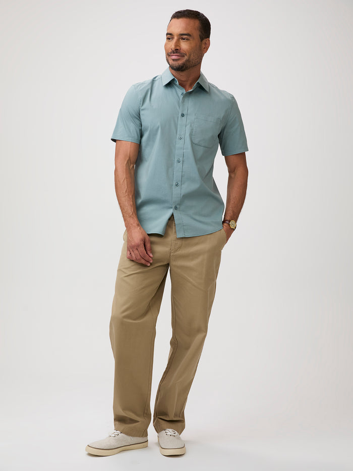 Man wearing a light blue-green button up shirt and khaki pants | stretch cotton-poly-spandex blend for all-day ease and mobility