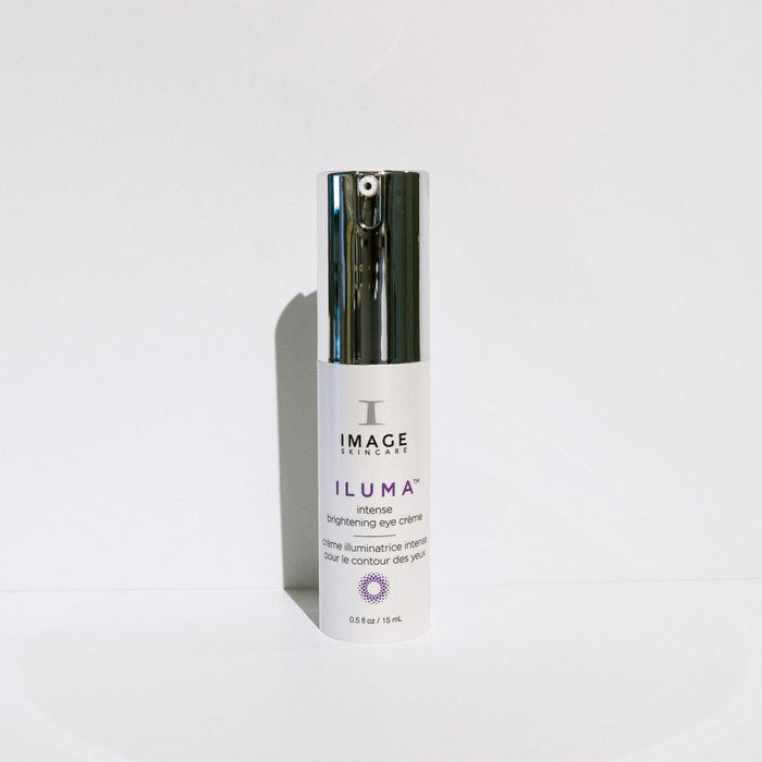 Bottle of ILUMA intense brightening eye crème | IMAGE Skincare, a white skincare product with a silver cap designed for eye care and brightening.