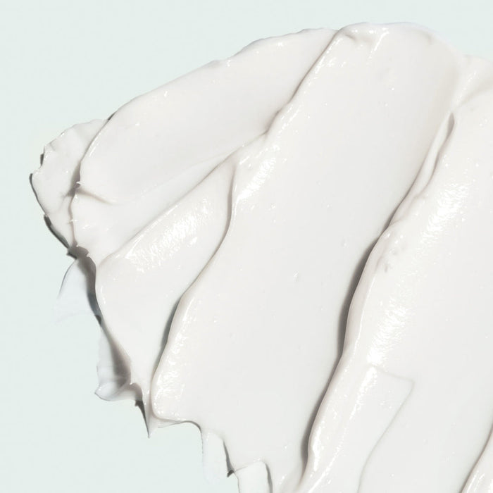 Close-up of smooth, creamy white texture of ILUMA intense brightening eye crème | IMAGE Skincare, highlighting its rich formulation for targeted skincare.