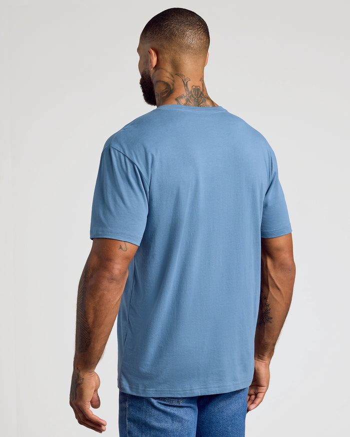 Man wearing Indigo Classic V-Neck shirt with jeans, arms relaxed.