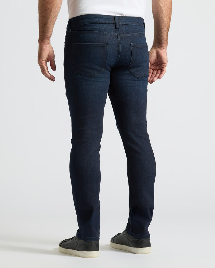Indigo Wash Slim Comfort Stretch Jeans worn with black sneakers.