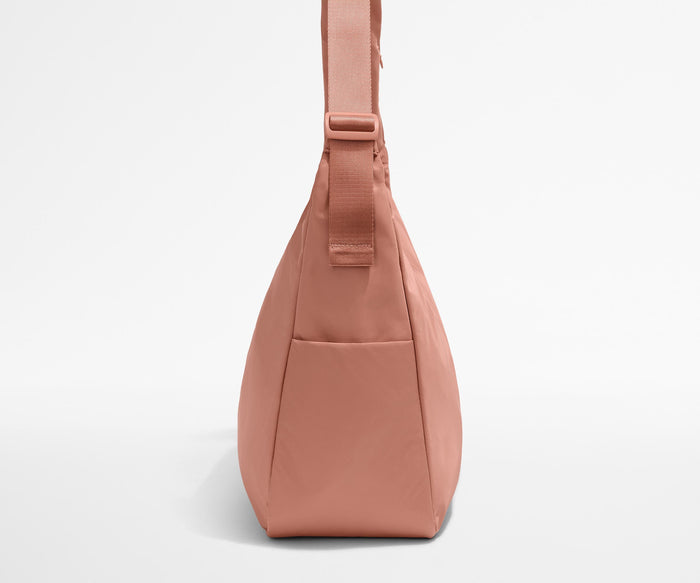 Side view of the Large Featherlight Crossbody showing the exterior bottle pocket