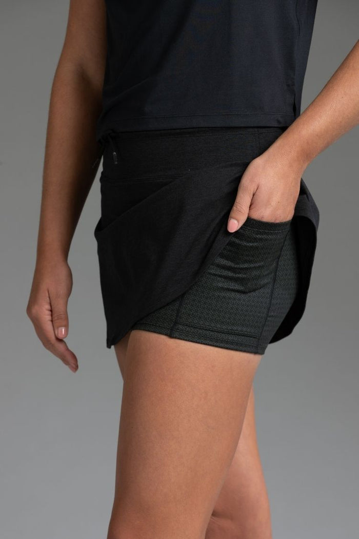 Person wearing a black athletic skirt on a gray background || Black Heather