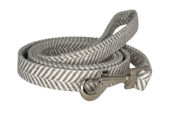 Gray and white striped dog leash with a metal clip on a white background