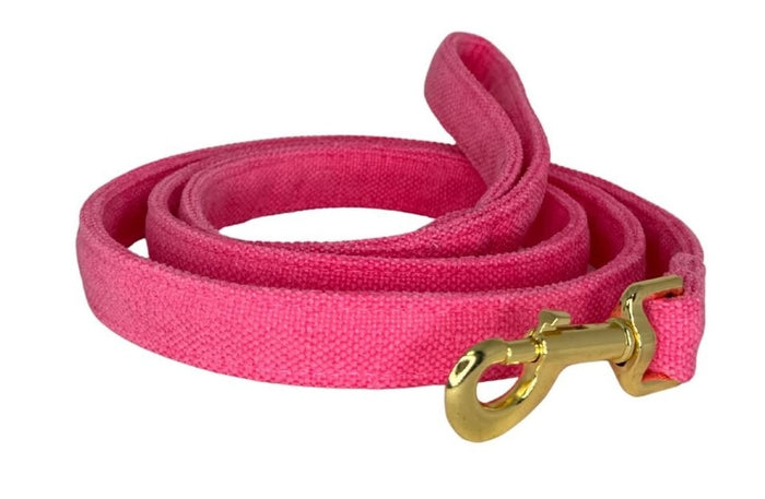 Pink dog leash with a gold clasp on a white background