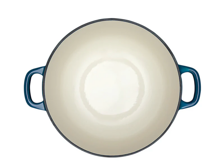 White interior of blue enameled cast iron Dutch oven on a white background