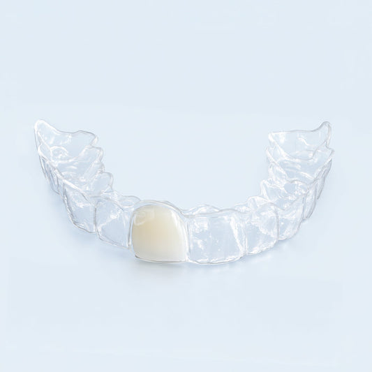 Clear upper retainer with built-in replacement tooth on blue surface for missing tooth
