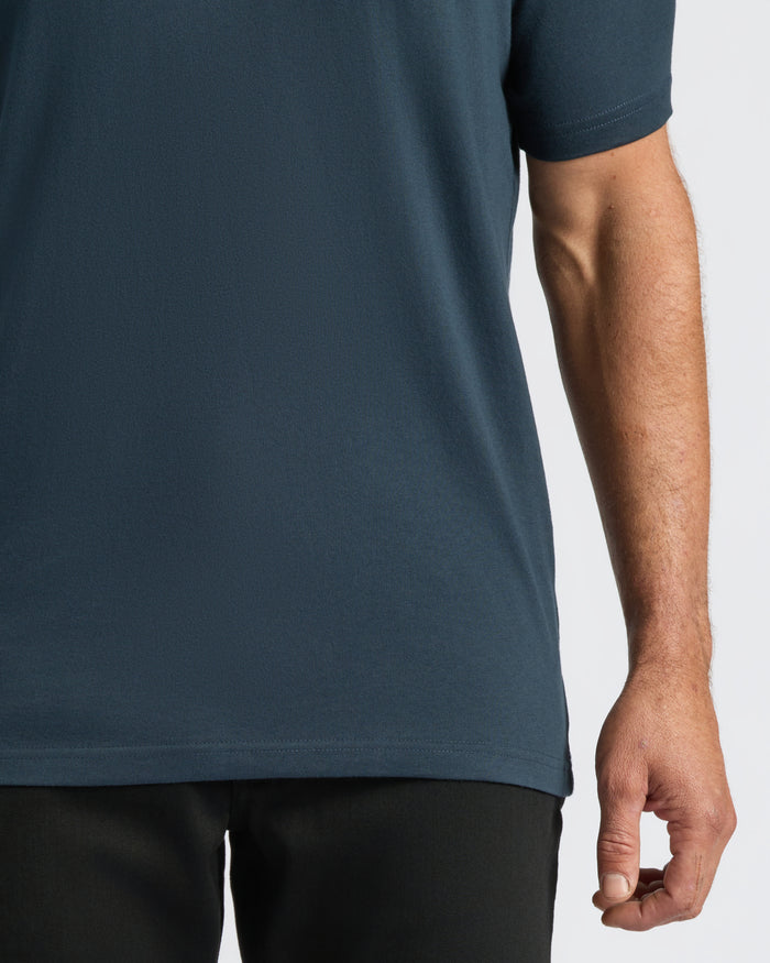 Person wearing Classic V-Neck T-shirt tucked into black pants.
