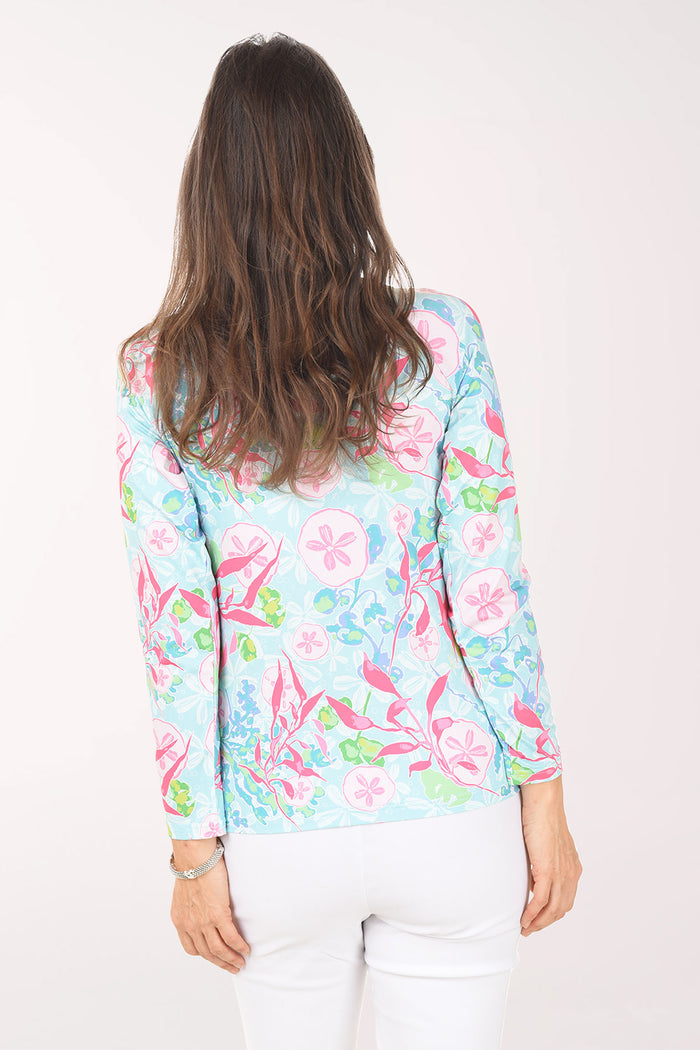 Woman wearing a colorful floral patterned shirt on a white background
