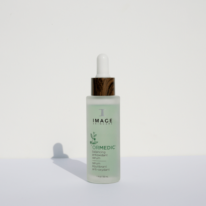 ORMEDIC balancing antioxidant serum | IMAGE Skincare in a frosted glass bottle with a white dropper and wood-textured collar, designed for skincare and wellness.