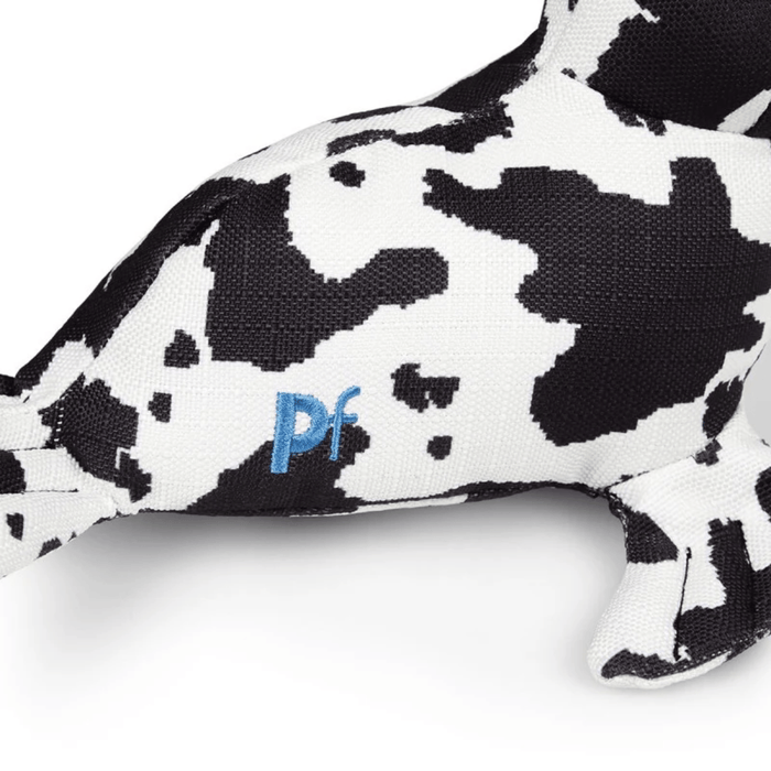 Close up view of black and white seal plush dog toy's side with stitch detailing of text 'PF' on a white background.
