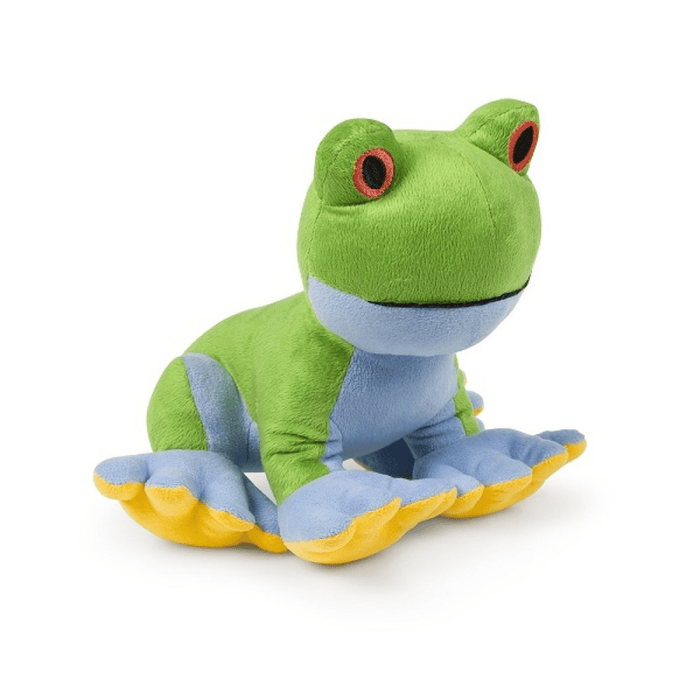 Side view of green frog plush dog toy with a blue underside, yellow feet and red eyes sitting on a white background.