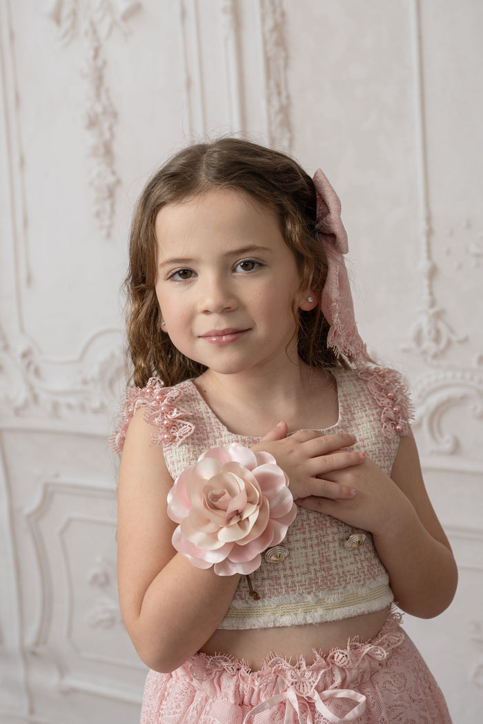 Child wearing pink flower neck tie styled with a blush outfit, featuring a delicate fabric rose for an elegant formal look