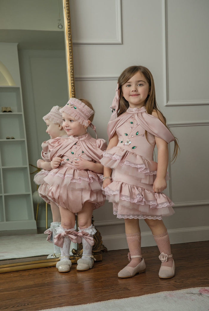 Pink ballerina hair sash styled on a young girl, highlighting the elegant pleated design and jeweled accents paired with matching ballerina dresses