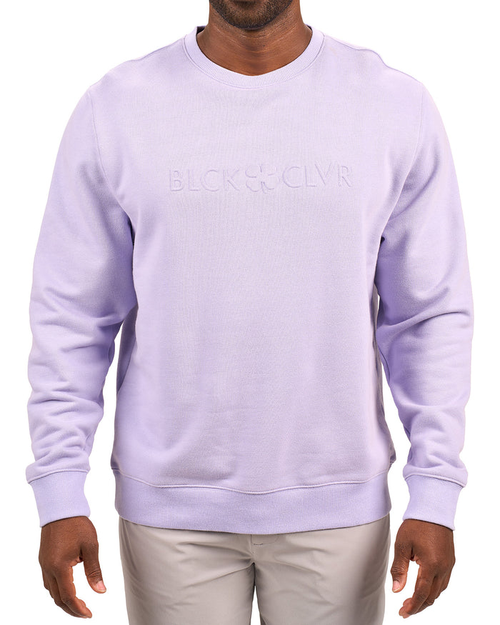 man wearing an light purple colored sweater from Black Clover with a 3d text BLCK CLVR on the chest