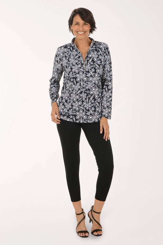 A woman modeling a long-sleeve button-up blouse with a black, white, and gray paisley pattern, paired with black cropped pants and black strappy high-heeled sandals, against a plain white studio background.